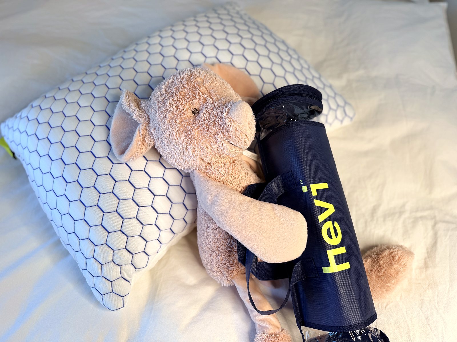 Vankúš Hevi Pillow a taška na náplň na posteli s plyšovou hračkou